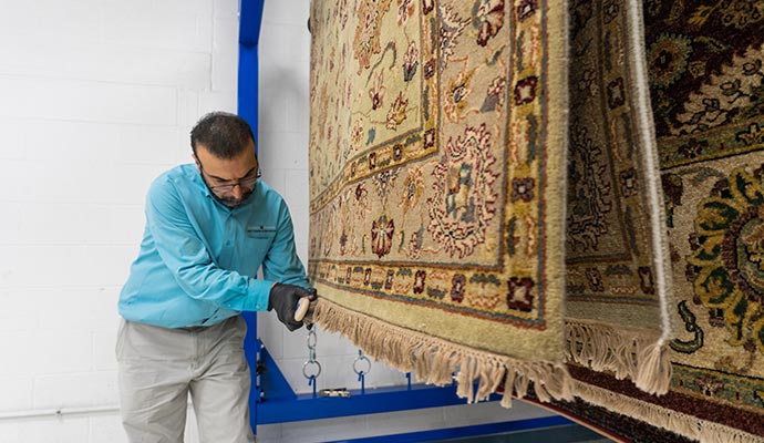 Rug cleaning technician performing final inspection