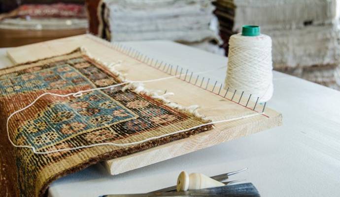 Close-up of a professional rug repair setup with tools and fabric materials
