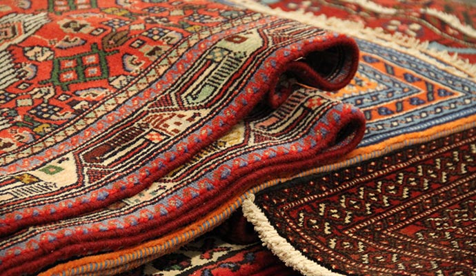 Stack of folded traditional patterned rugs