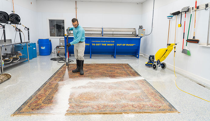Technician washing an oriental rug at a professional facility