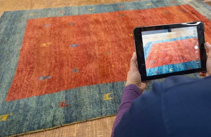 inspecting rug with tablet